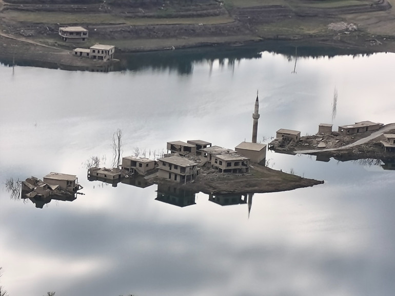 Barajla beraber boşaltılan ve kısmen görülebilen köy evleri, tamamen su altında kalırken, minare bölgedeki ve son yapı olarak dikkat çekiyor.
